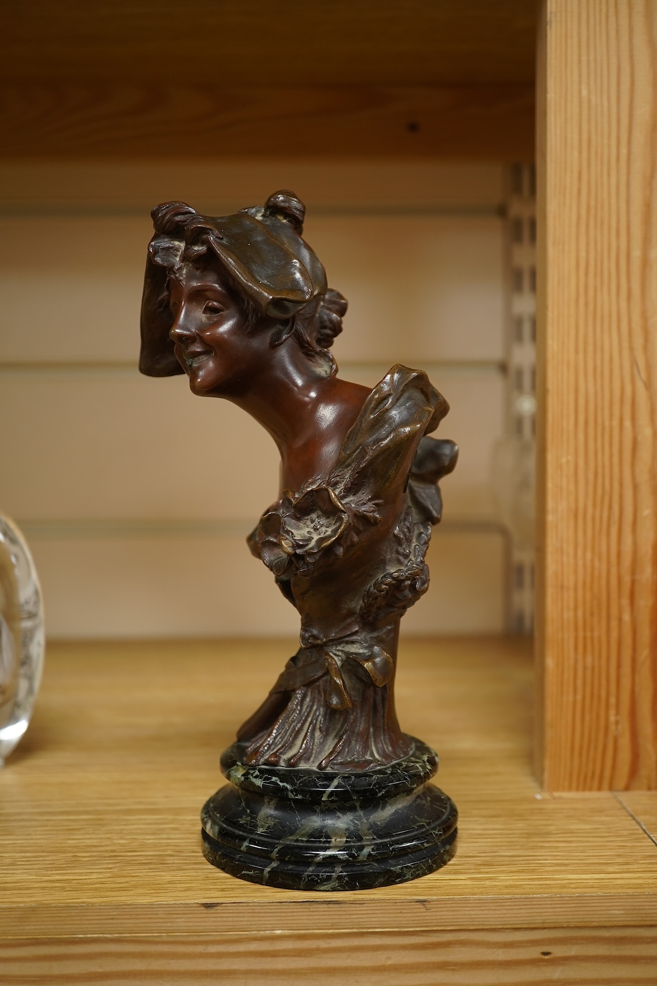 A late 19th century bronze bust of a lady in a hat with floral decoration , mounted on marble, signed, 21.5cm high.